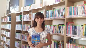 Kitap kurdu minik Elif kütüphanede gönüllü çalışıyor