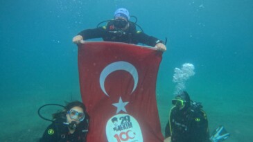 GÖMEÇ’TE KAYMAKAM VE BELEDİYE BAŞKANI CUMHURİYETİN 100. YILDÖNÜMÜ İÇİN DENİZE DALDI